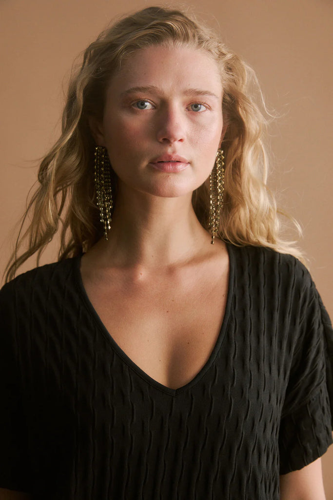 Woman wearing a black dress.  Elk Orta Dress Black,