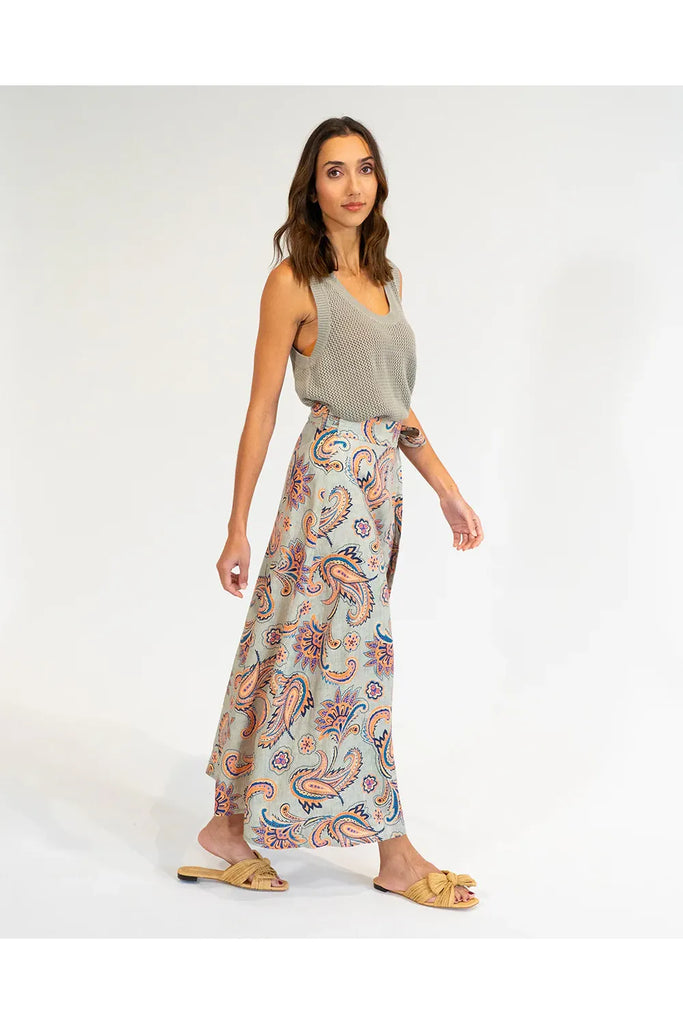 Woman wearing a patterned skirt and sleeveless top on a white background. Elms & King La Rocco Skirt in paisley print.