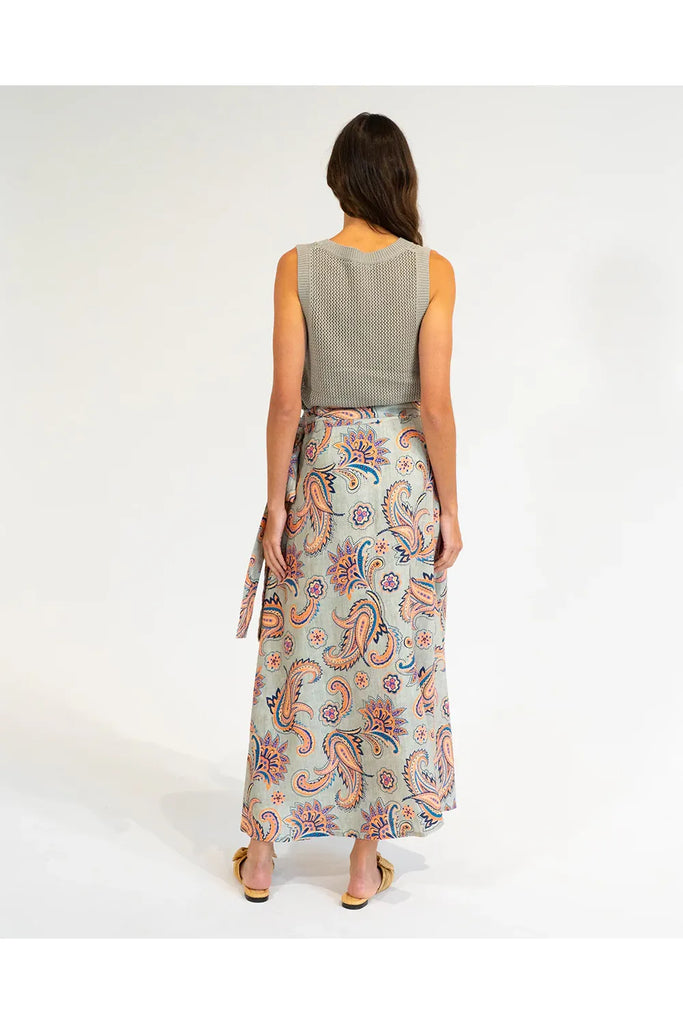 Woman wearing a patterned skirt and sleeveless top on a white background. Elms & King La Rocco Skirt in paisley print.