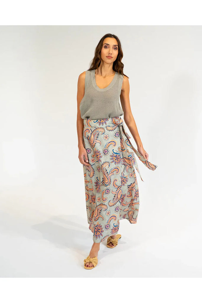 Woman wearing a patterned skirt and sleeveless top on a white background. Elms & King La Rocco Skirt in paisley print.