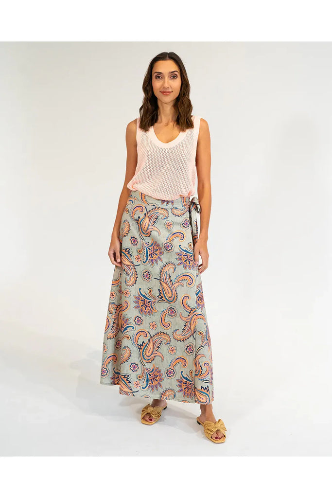Woman wearing a patterned skirt and sleeveless top on a white background. Elms & King La Rocco Skirt in paisley print.