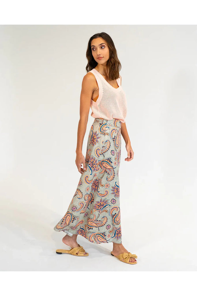 Woman wearing a patterned skirt and sleeveless top on a white background. Elms & King La Rocco Skirt in paisley print.