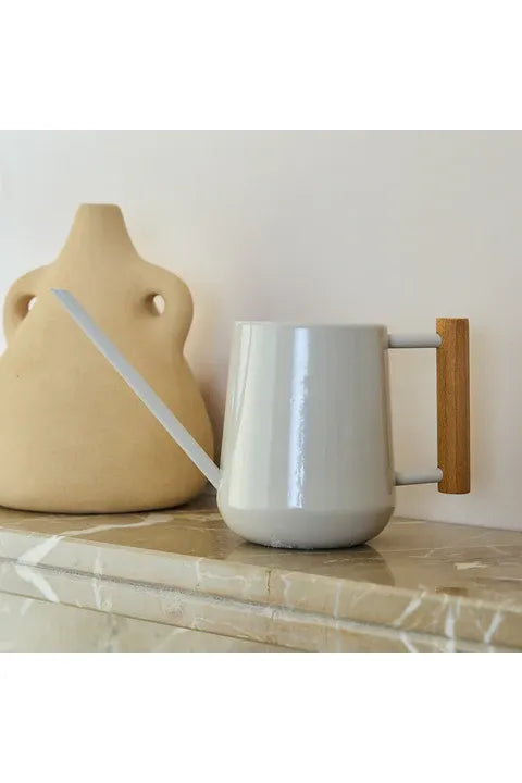 Burgeon & Ball Mushroom coloured Collectors Indoor watering can with a wooden handle on a marble surface, next to a beige ceramic vase.