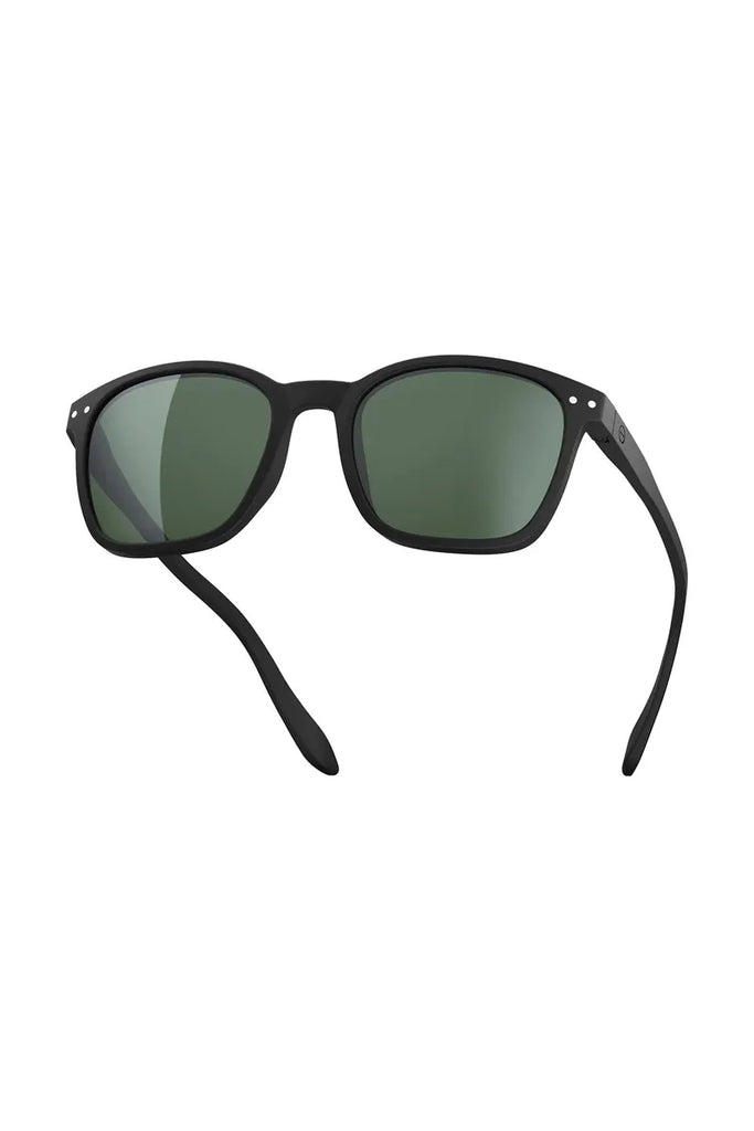 Izipizi polarised black sunglasses with green lenses on a light grey 