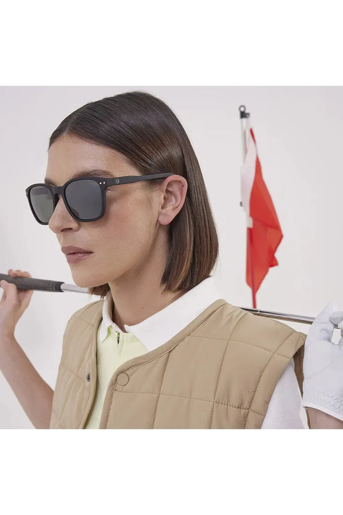  A woman wearing Izipizi polarised black sunglasses against a neutral background.