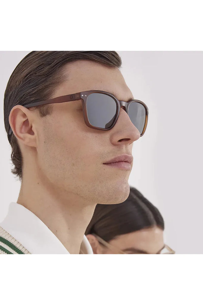 A man wearing Izipizi polarised sunglasses with a blurred background.