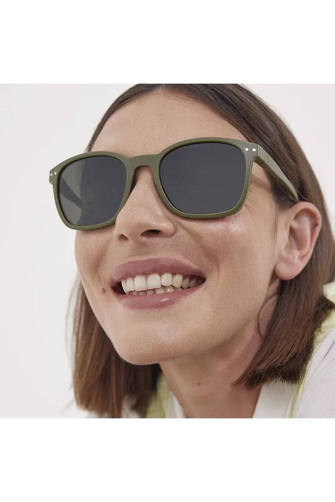 A woman wearing Izipizi Polarised Sport Khaki  sunglasses with a neutral background