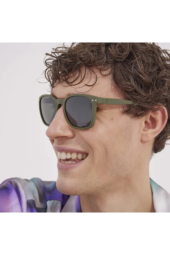 A man wearing Izipizi Khaki green polarised sunglasses with a neutral background