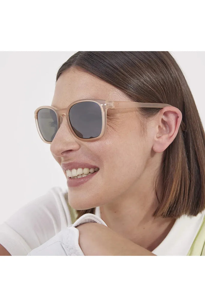 A woman wearing Izipizi Sport Journey Good weather sunglasses in Sand Beige with a plain background