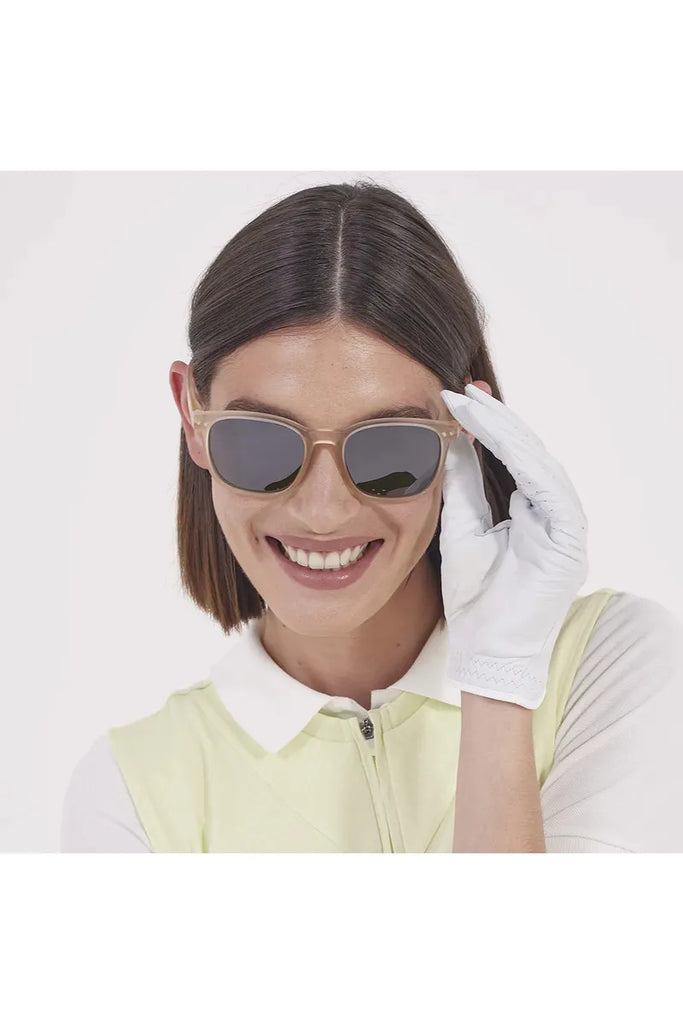 A woman wearing Izipizi Sports sunglasses and a white glove on a plain background