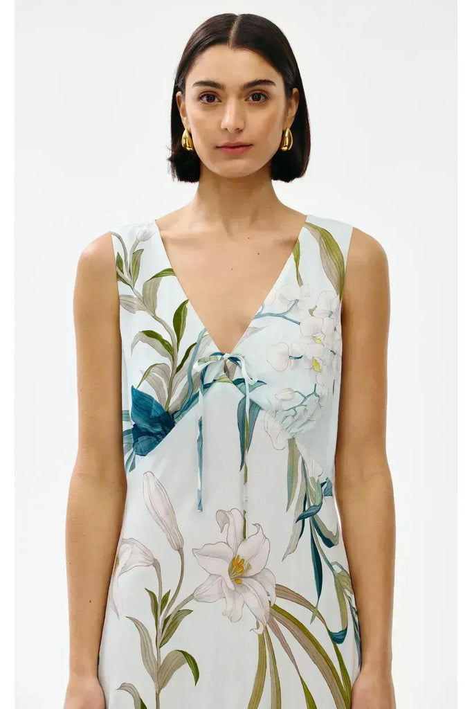 Woman wearing a floral sleeveless dress on a white background. Kinney Alice dress in Portofino print.