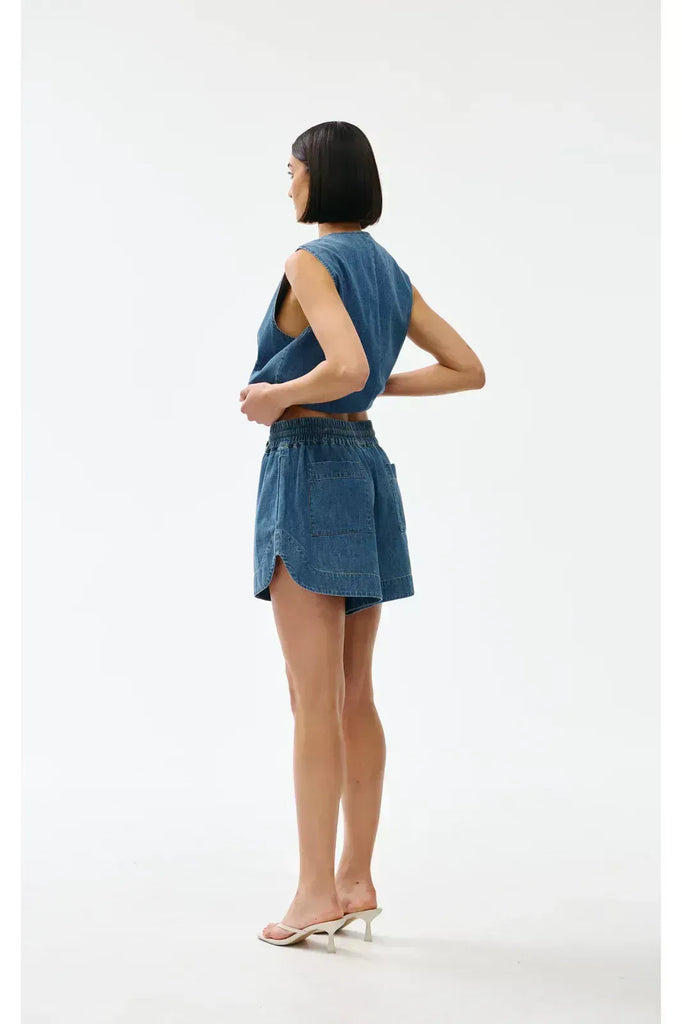 Woman wearing a blue denim outfit on a white background. Kinney Juniper Shorts 