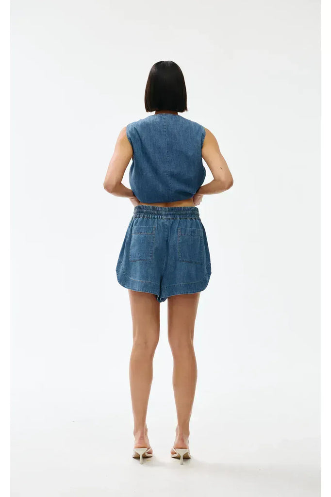 Woman wearing a blue denim outfit on a white background. Kinney Juniper Shorts 