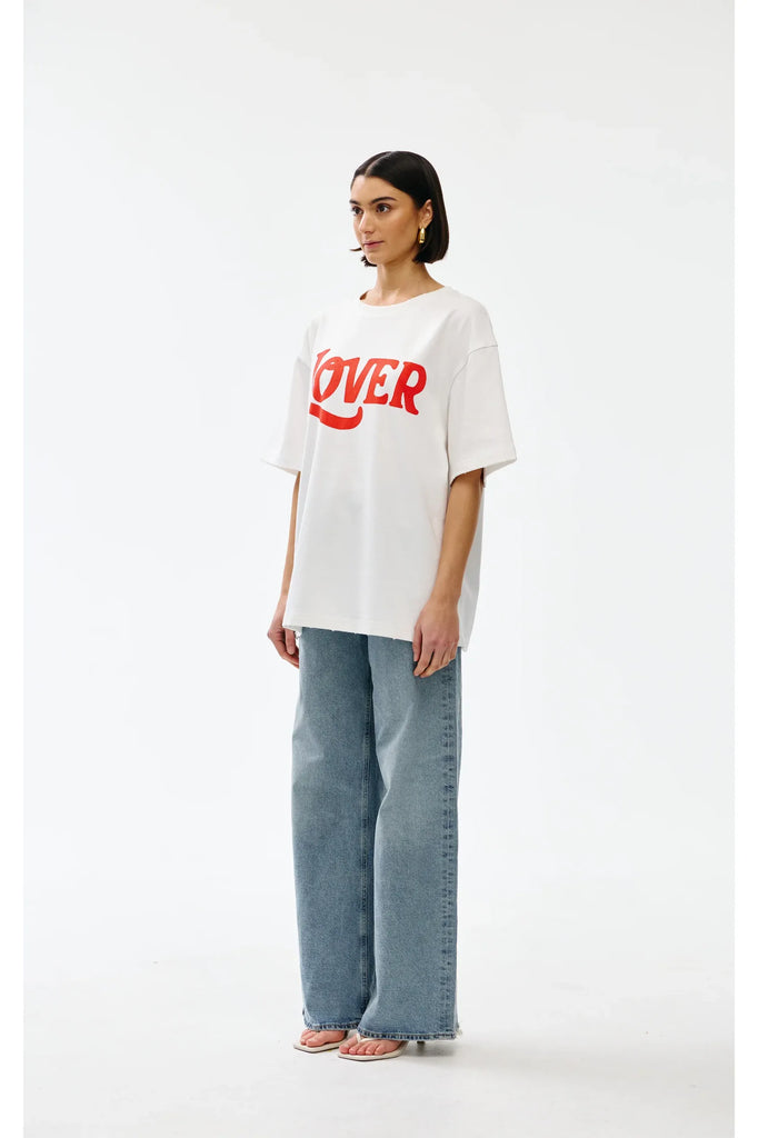 Person wearing a white t-shirt with red text and blue jeans on a white background