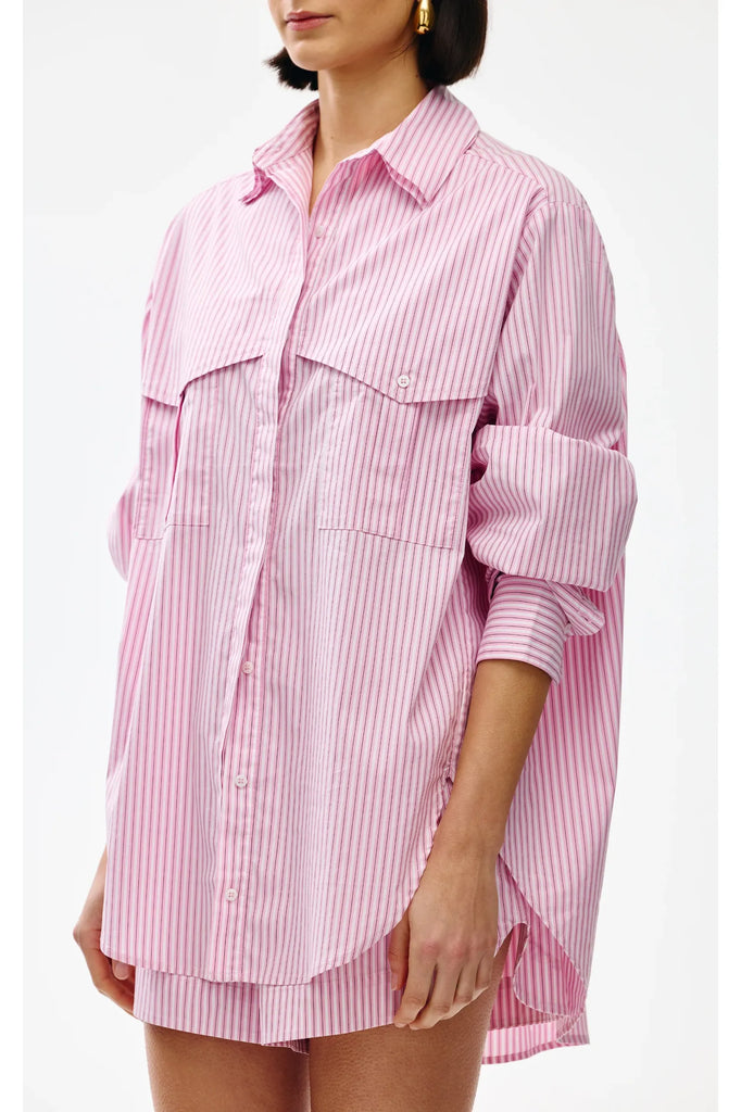 Pink and white striped shirt worn by a person on a white background