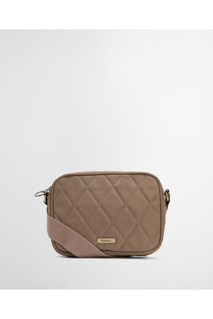 Quilted beige handbag on a light gray background. Barbour Quilted crossbody bag in sand.