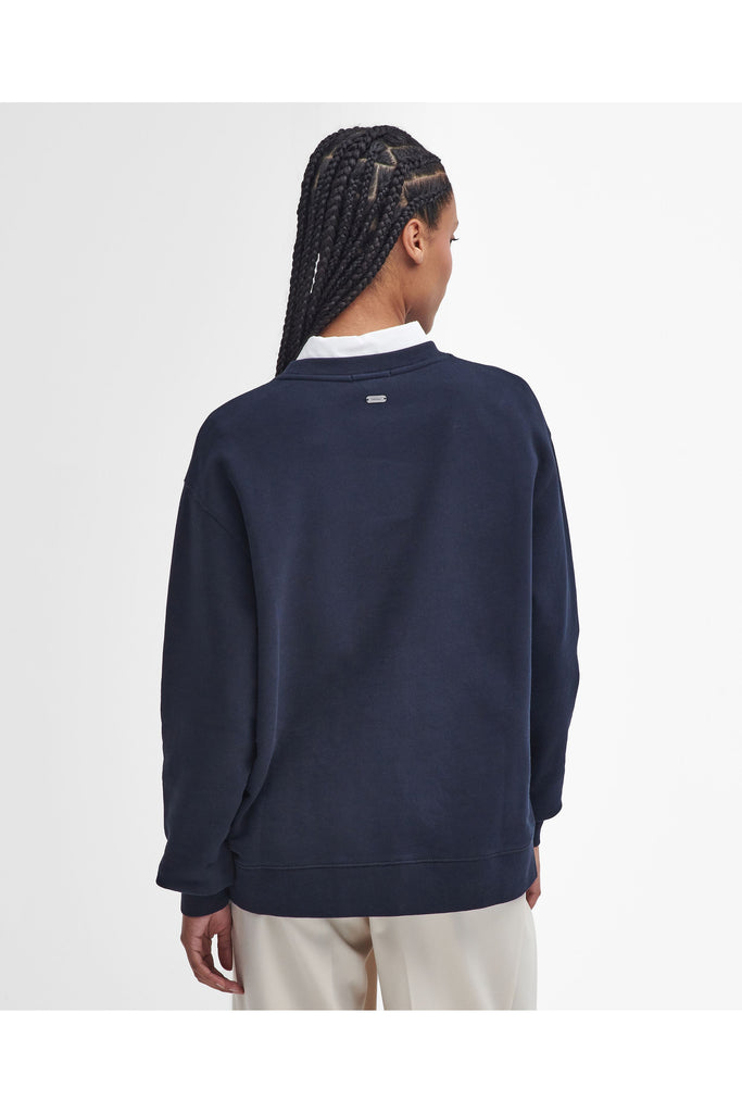 Person wearing a navy Barbour sweatshirt with a white collar on a light gray background. Northumberland Sweatshirt in Navy and Cloud.