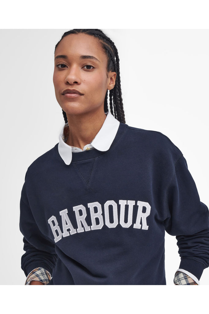 Person wearing a navy Barbour sweatshirt with a white collar on a light gray background. Northumberland Sweatshirt in Navy and Cloud.