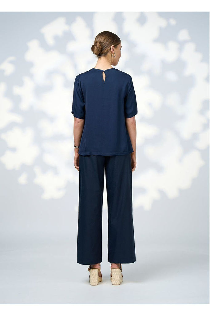 Woman wearing a Jada Top in Indigo from Loobies Story with a navy pant