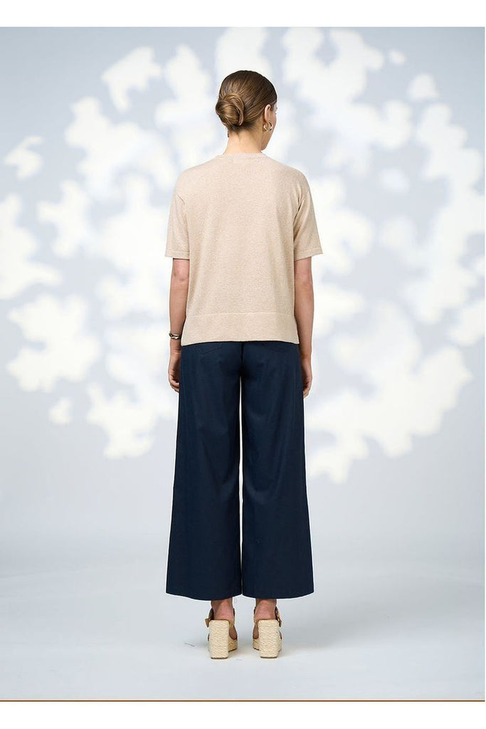 Woman wearing the Mica Tee in Champagne from Loobie's Story with a beige top and sandals