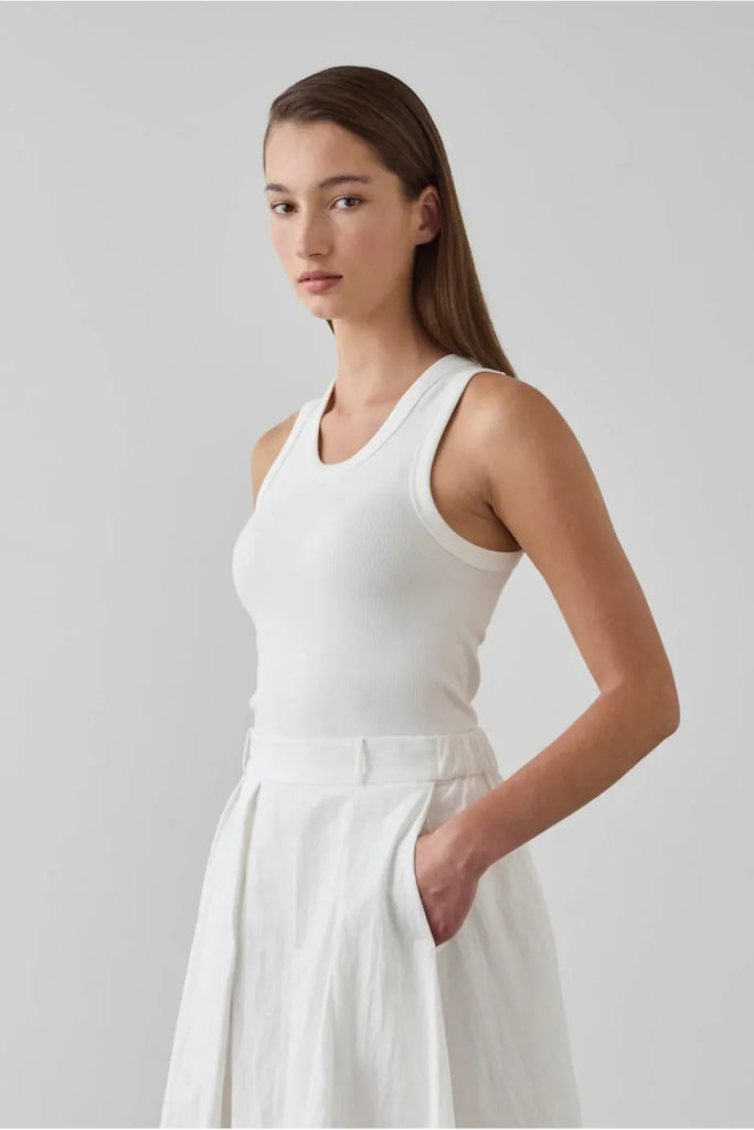 Woman wearing a white sleeveless top. Laing Cotton Tank in Ecru.