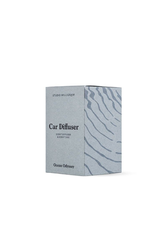 Studio Milligram car diffuser set packaged in a blue/grey box with a wavy design on it sitting against a white background