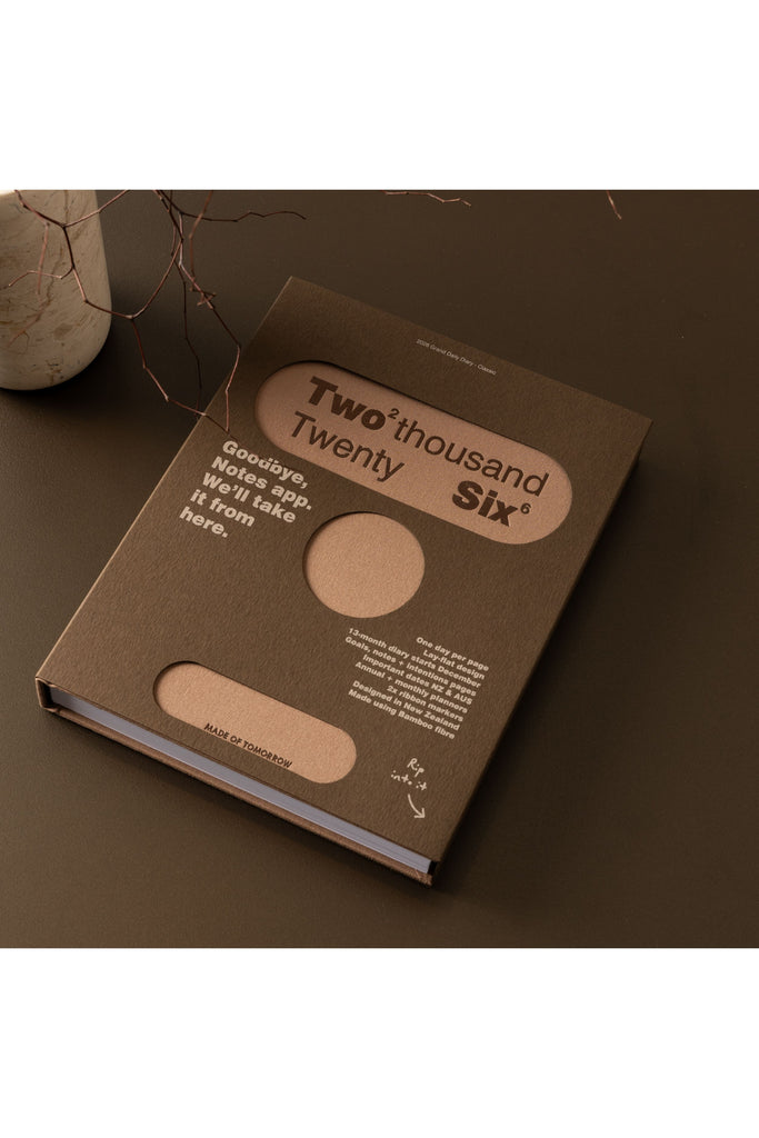 The Made of Tomorrow 2026 Grand Daily Classic Diary in Toffee showcases "Two Thousand Twenty-Six" proudly on its front cover. It's beautifully presented in its stylish packaging against a dark backdrop, with delightful cutouts that reveal the vibrant diary color and the year, adding a touch of excitement for the coming year!d the year printed on it.d the year printed on it.d the year printed on it.d the year printed on it.