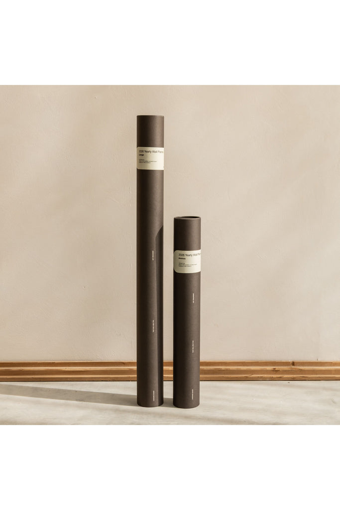 Made of Tomorrow black cylindrical tubes that hold the 2026 Yearly Wall Planners with labels on a beige background