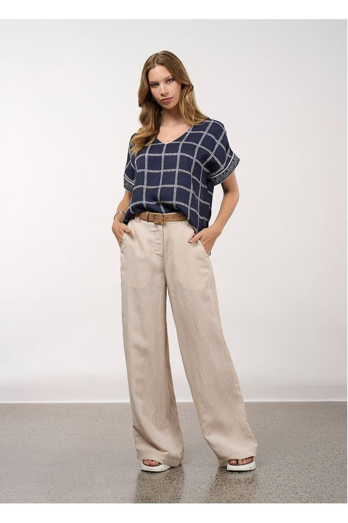 Woman wearing a blue checkered top and beige pants against a white background, Loobies Story Lyrical Top