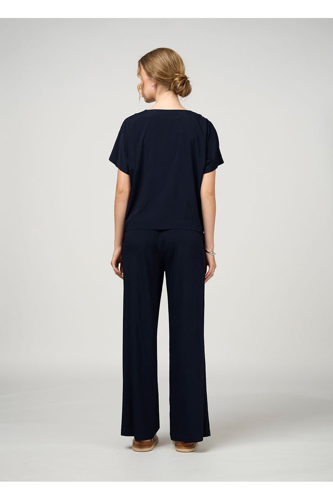 Woman wearing a black outfit on a white background. Madly Sweetly Occasion Top in Black.