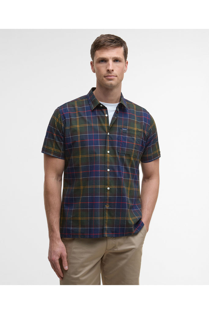 Man wearing a plaid shirt and beige pants on a white background. Barbour Gordon Summer Shirt in Classic Tartan.