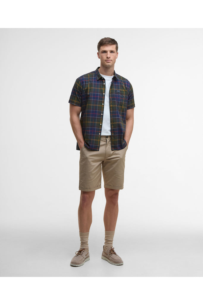 Man wearing a plaid shirt and beige pants on a white background. Barbour Gordon Summer Shirt in Classic Tartan.