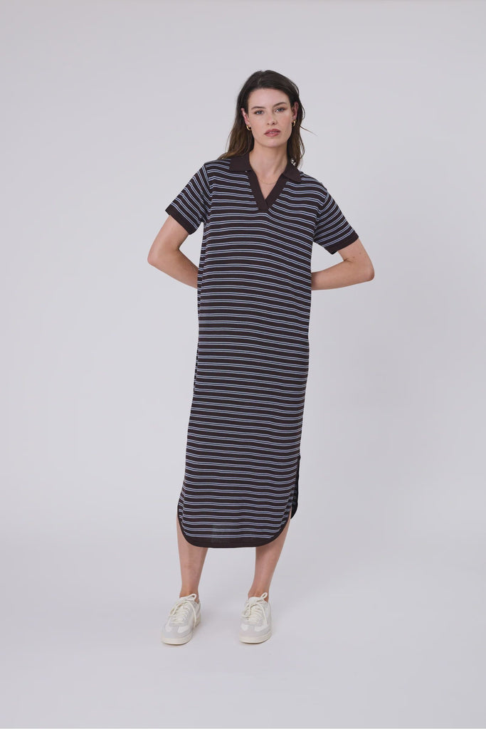 Woman wearing a chocolate brown and blue striped polo dress on a white background. Marlow Chime Knit Polo Dress in Carob Stripe.