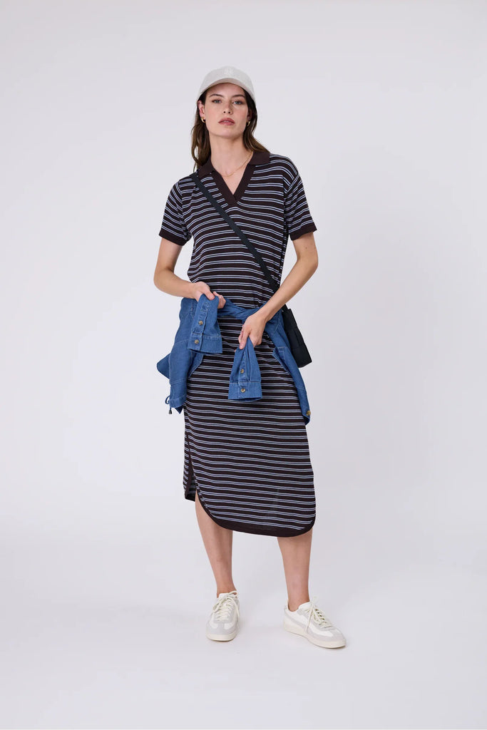 Woman wearing a chocolate brown and blue striped polo dress on a white background. Marlow Chime Knit Polo Dress in Carob Stripe.