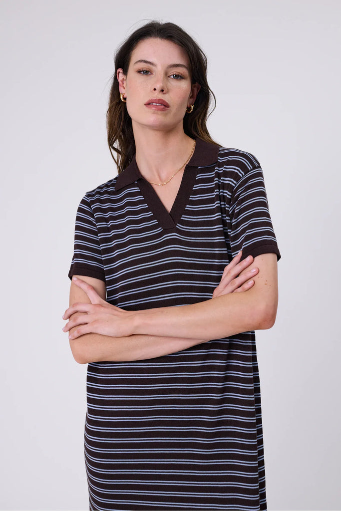 Woman wearing a chocolate brown and blue striped polo dress on a white background. Marlow Chime Knit Polo Dress in Carob Stripe.