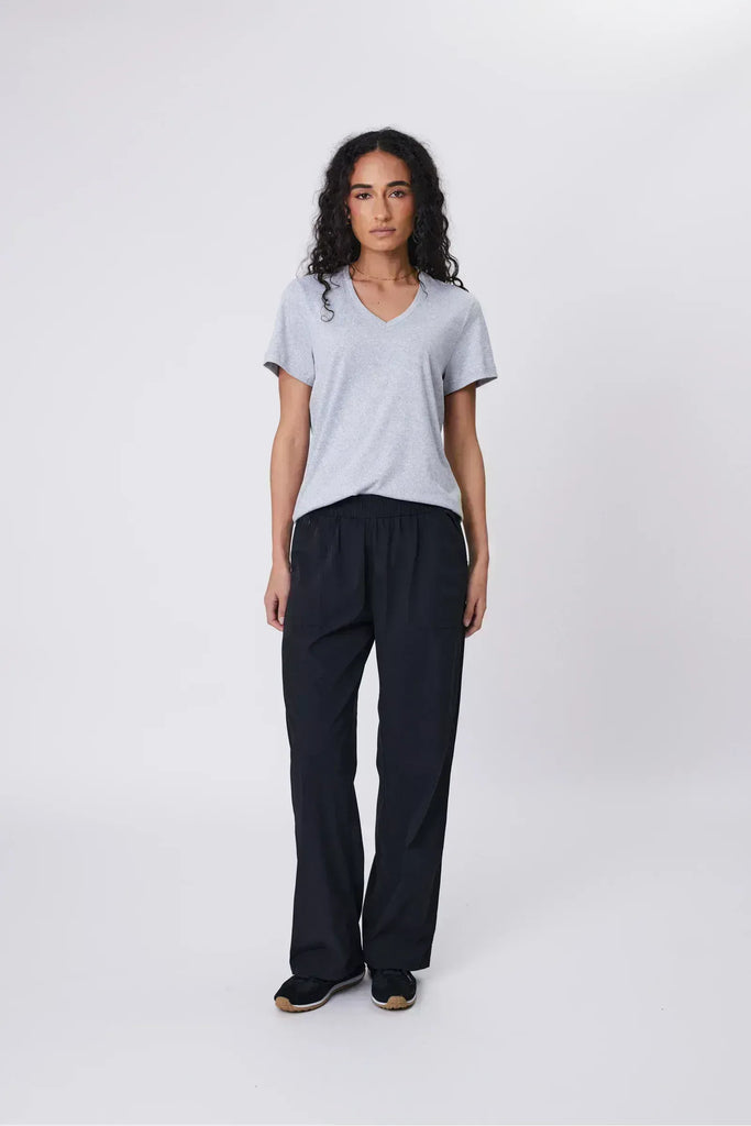 Woman wearing a gray shirt and black pants on a white background. Marlow Intrepid Pant 2.0 in Black