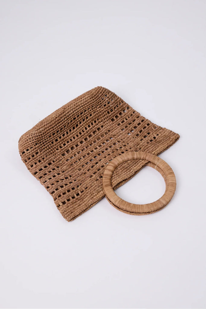 Woven raffia handbag on a light grey background. Milano Mini Bucket Bag in Tea.