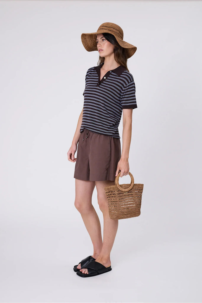 Woman wearing a wide brim sun hat and stripe top against a grey background. Marlow Mykonos Wide Brim Hat in Tea.