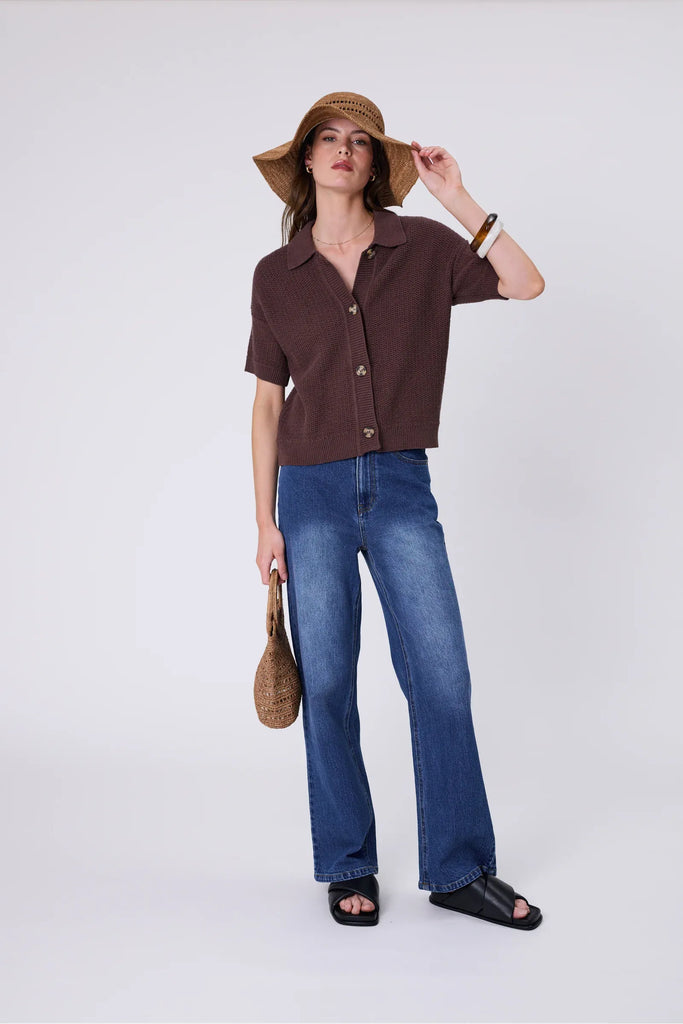 Woman wearing a wide brim sun hat and brown top against a grey background. Marlow Mykonos Wide Brim Hat in Tea.