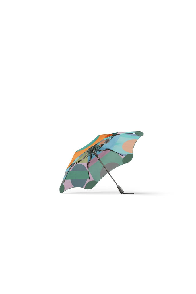 Blunt Metro Umbrella Limited Edition collaboration with Daimon Downey. Colourful umbrella featuring a geometric pattern, showing the side view of the umbrella against a white background.