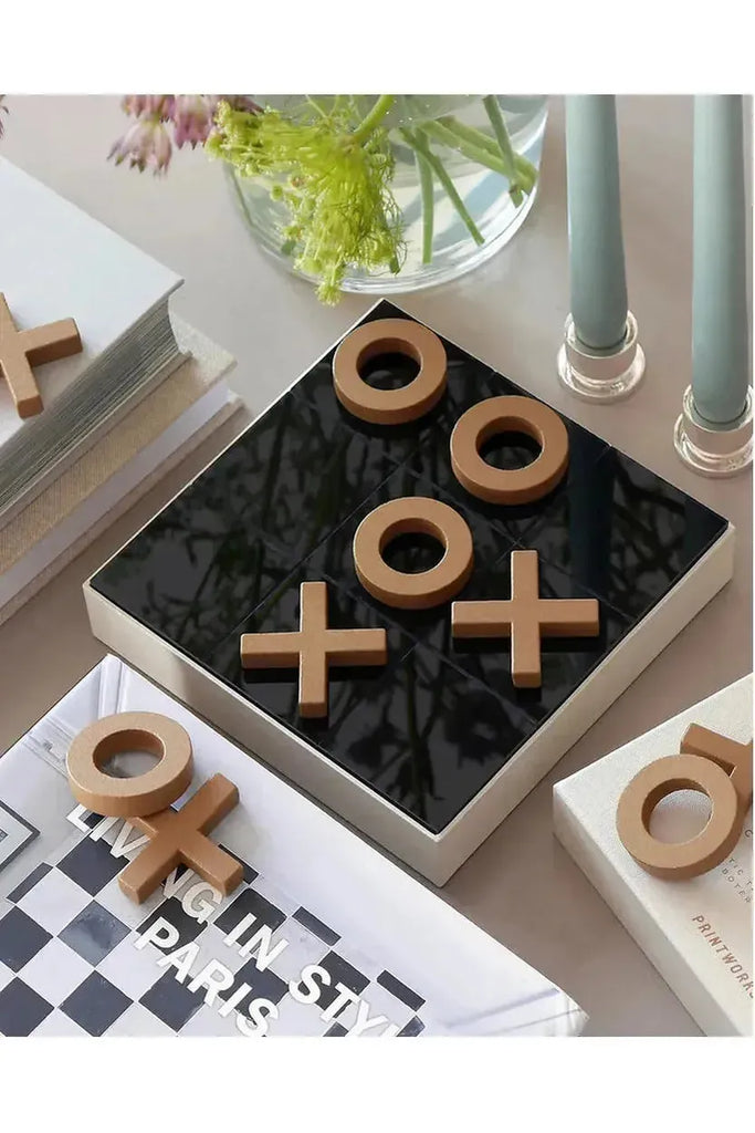 Printworks Tic-tac-toe game set on a table with books and a vase in the background
