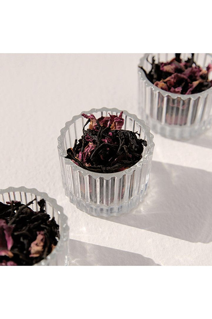 On Sundays Organic Loose Leaf Earl Grey Tea.  Tea Leaves shown photographed sitting in small glass vessels showing the leaves and rose petals blended with the tea leaves.