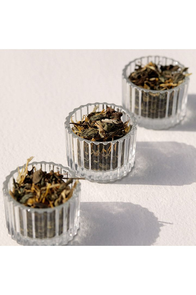 On Sundays Ease Organic Loose Leaf Tea laid out in little pinch pots so the viewer may see the blend of peppermint, calendula petals, licorice root, fennel seeds