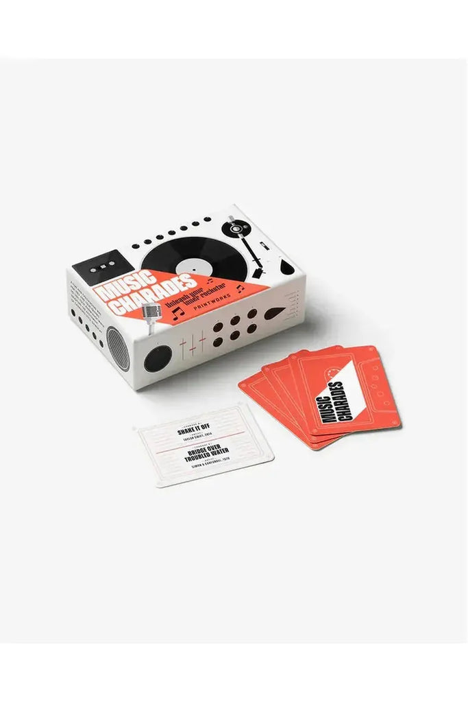 Printworks Music Charades Card Game. Music charade cards are displayed in front of a cassette-like packaging box on a white background.