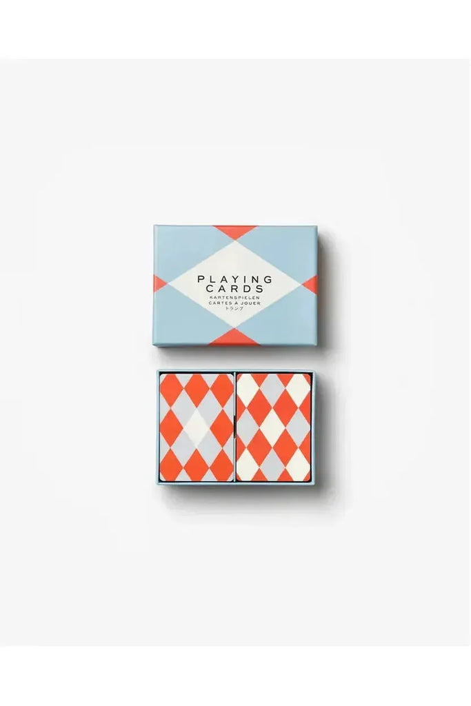 Two vibrant sets of playing cards are beautifully displayed in an open box adorned with a cheerful geometric design in soft blue, red, and white. The box lid mirrors this lively pattern, creating an inviting home for both card sets.