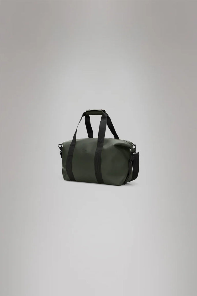 Rains Green duffel weekend bag with black straps on a light gray background