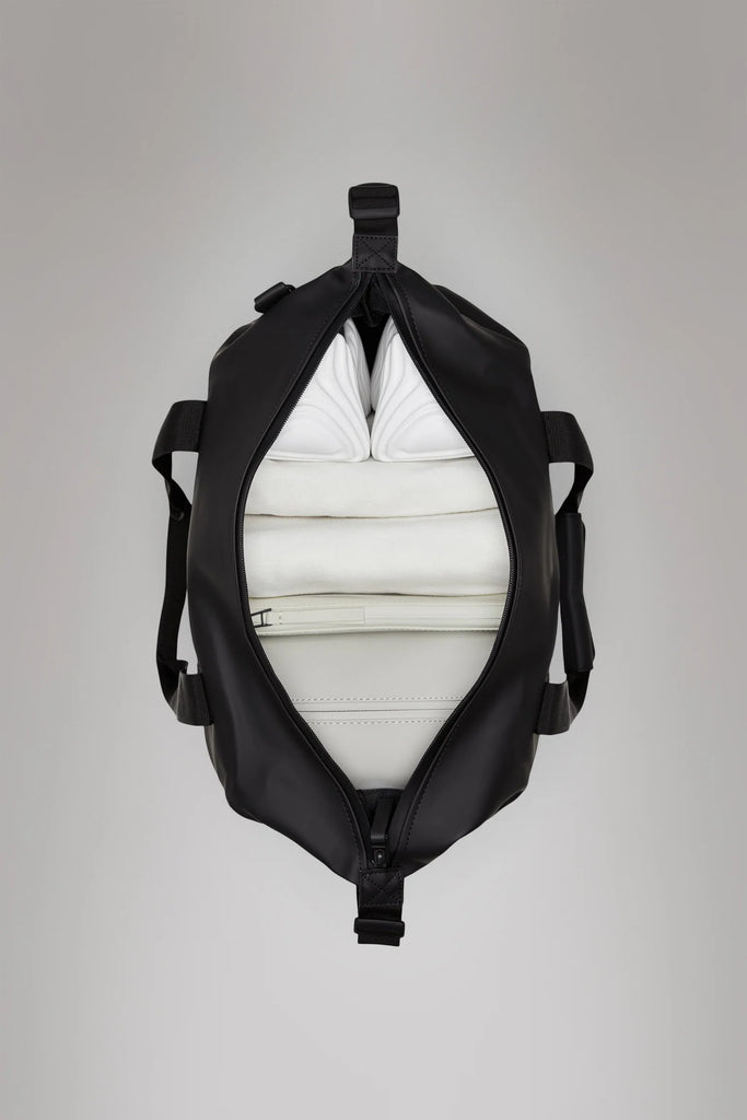 Rains Green duffel weekend bag open view from the top with black straps on a light gray background 