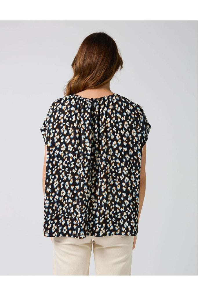 Woman wearing a Stella and Gemma Clio Top in Navy Leopard print against a white background back view