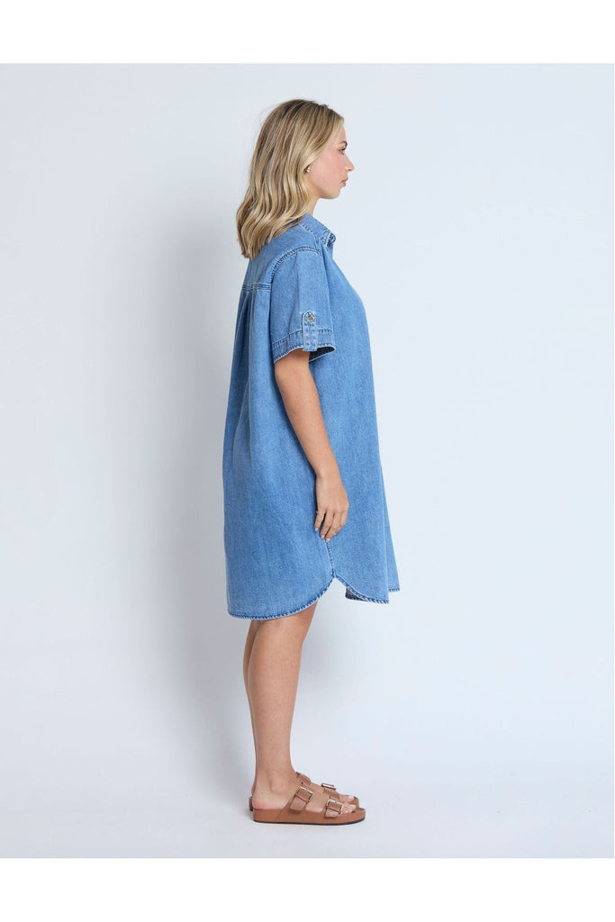 Woman wearing a Stella and Gemma Vinnie Dress in blue denim against a white background side view