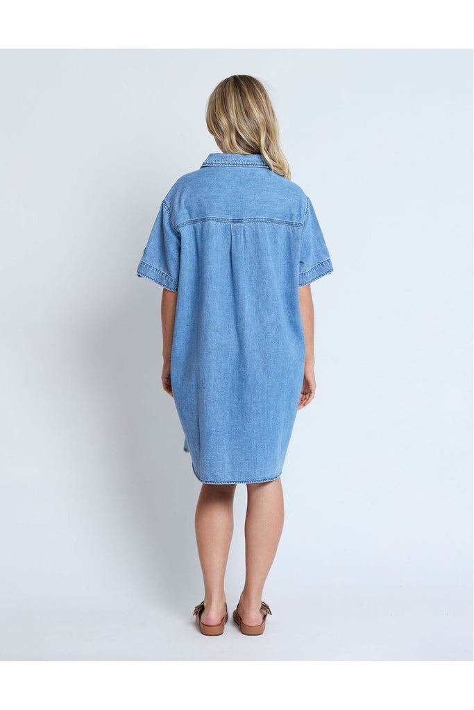 Woman wearing a Stella and Gemma Vinnie Dress in blue denim against a white background back view